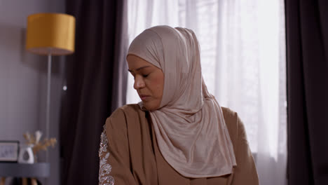 Close-Up-Of-Muslim-Woman-Wearing-Hijab-At-Home-Praying-Kneeling-On-Prayer-Mat-7